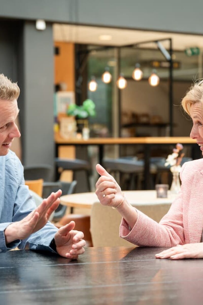 Leiderschapscoaching in een-op-een gesprek met coach Ine van den Heijkant aan een tafel in overleg