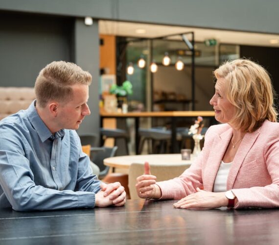 Leiderschapscoaching in een-op-een gesprek met coach Ine van den Heijkant aan een tafel in overleg