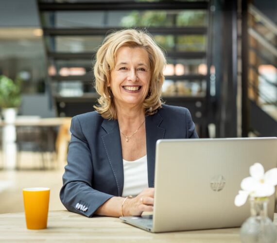Portret van teamcoach Ine van den Heijkant, zij is aan het werk achter haar laptop