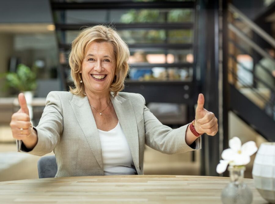 Portret van Ine van den Heijkant met de duimen omhoog trots op haar klanten bij zorg, gemeente en overheid