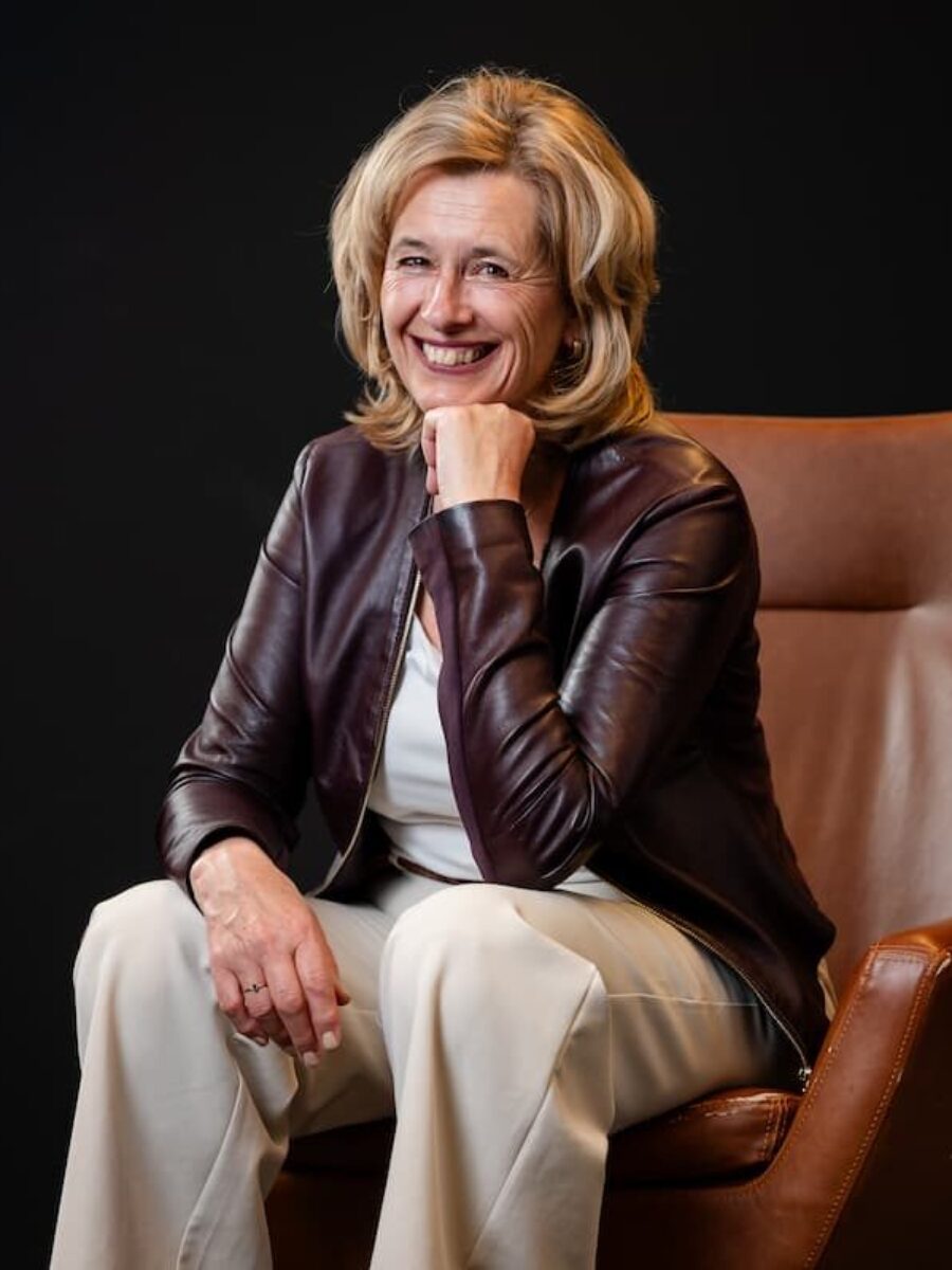 Portret op leren stoel van team- en organisatiecoach Ine van de Heijkant