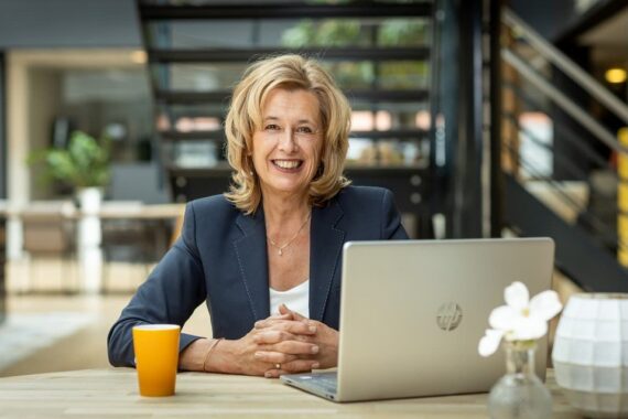 Portret van teamcoach Ine van den Heijkant, zij is aan het werk achter haar laptop